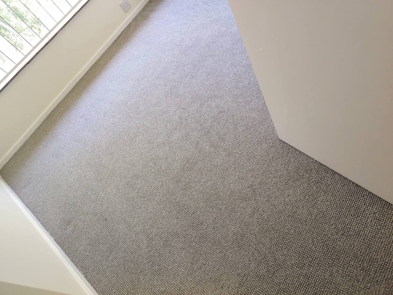 Close view of a light grey carpet in a room