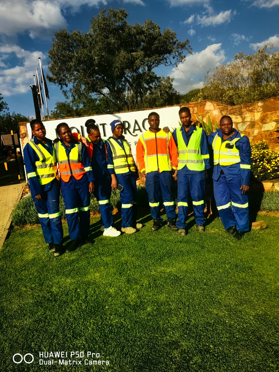 Seven Estlas cleaners in reflective vests at a client estate entrance
