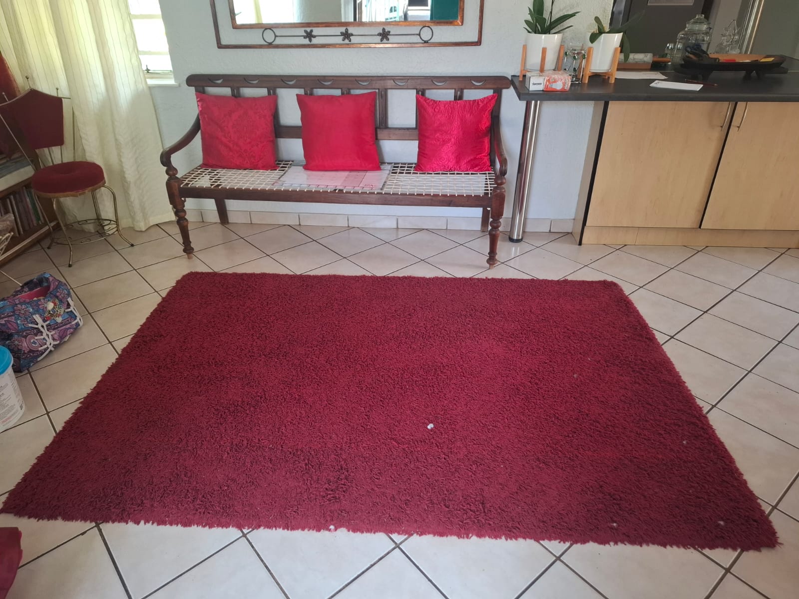 Clean red shaggy rug on a tiled floor