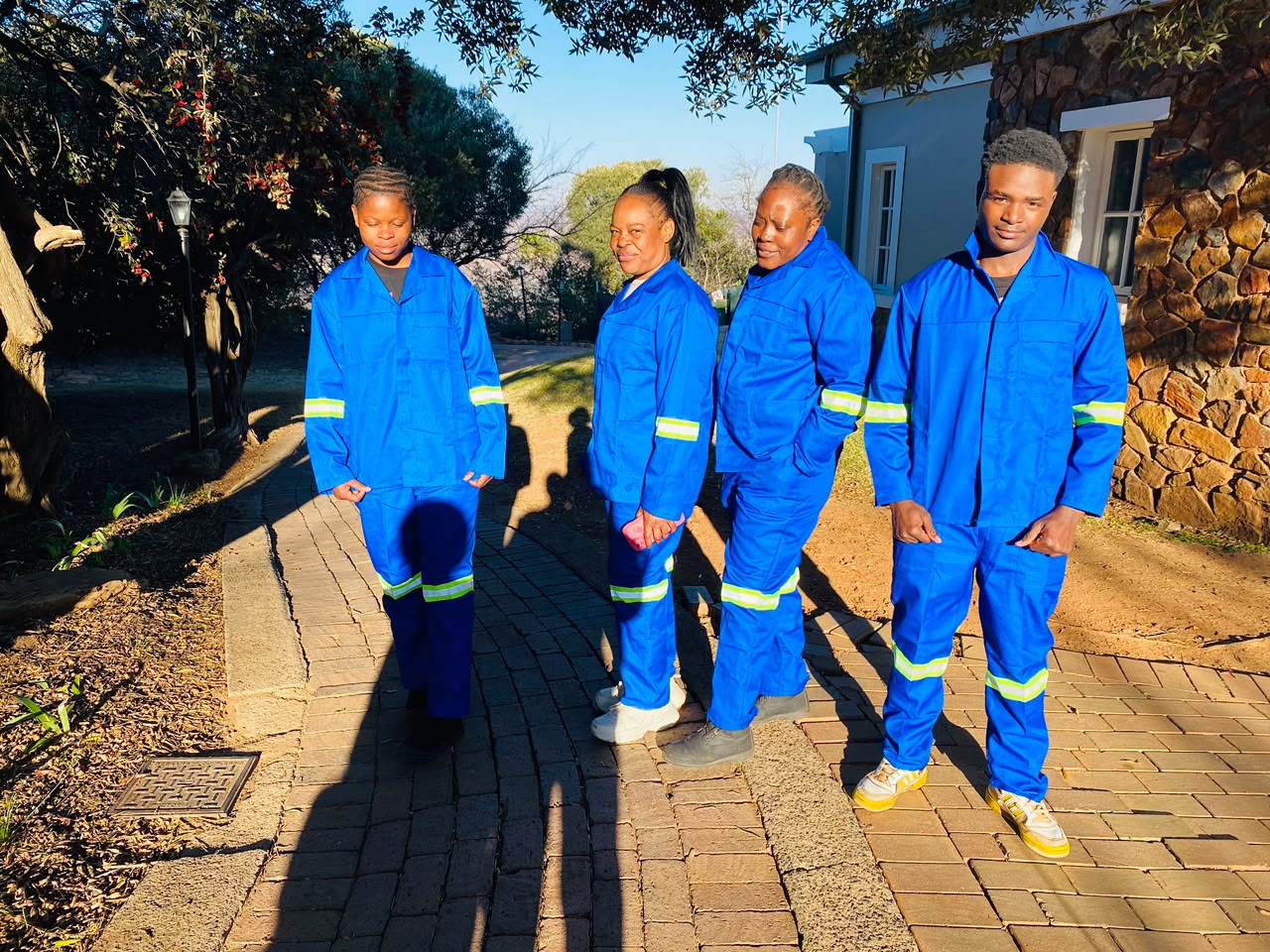 Four Estlas cleaners in blue reflective uniforms