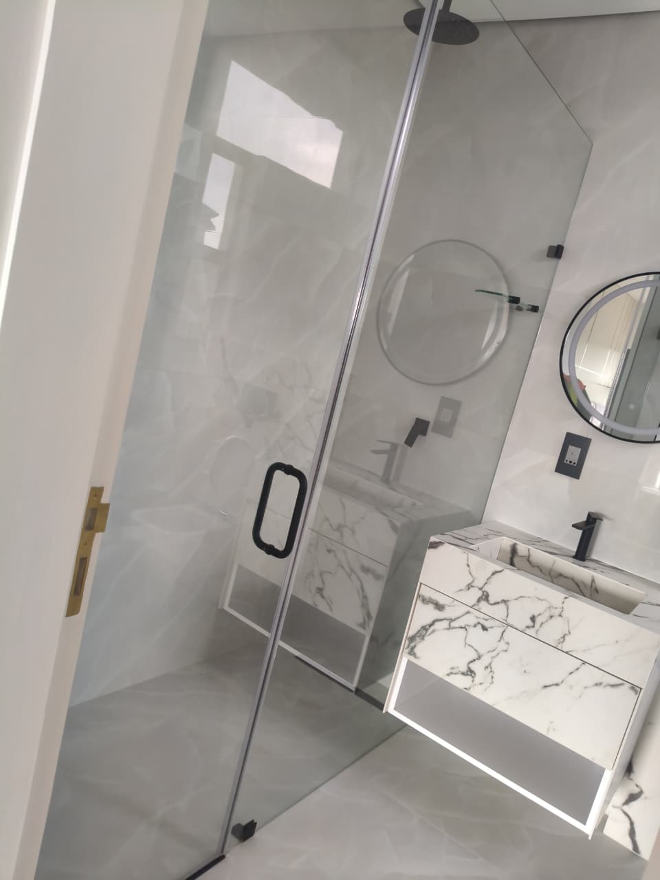 Clean glass shower and marble vanity