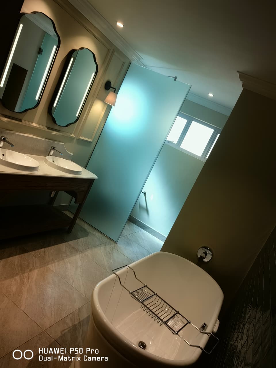 Bathroom with twin basins, mirrors and a freestanding bath
