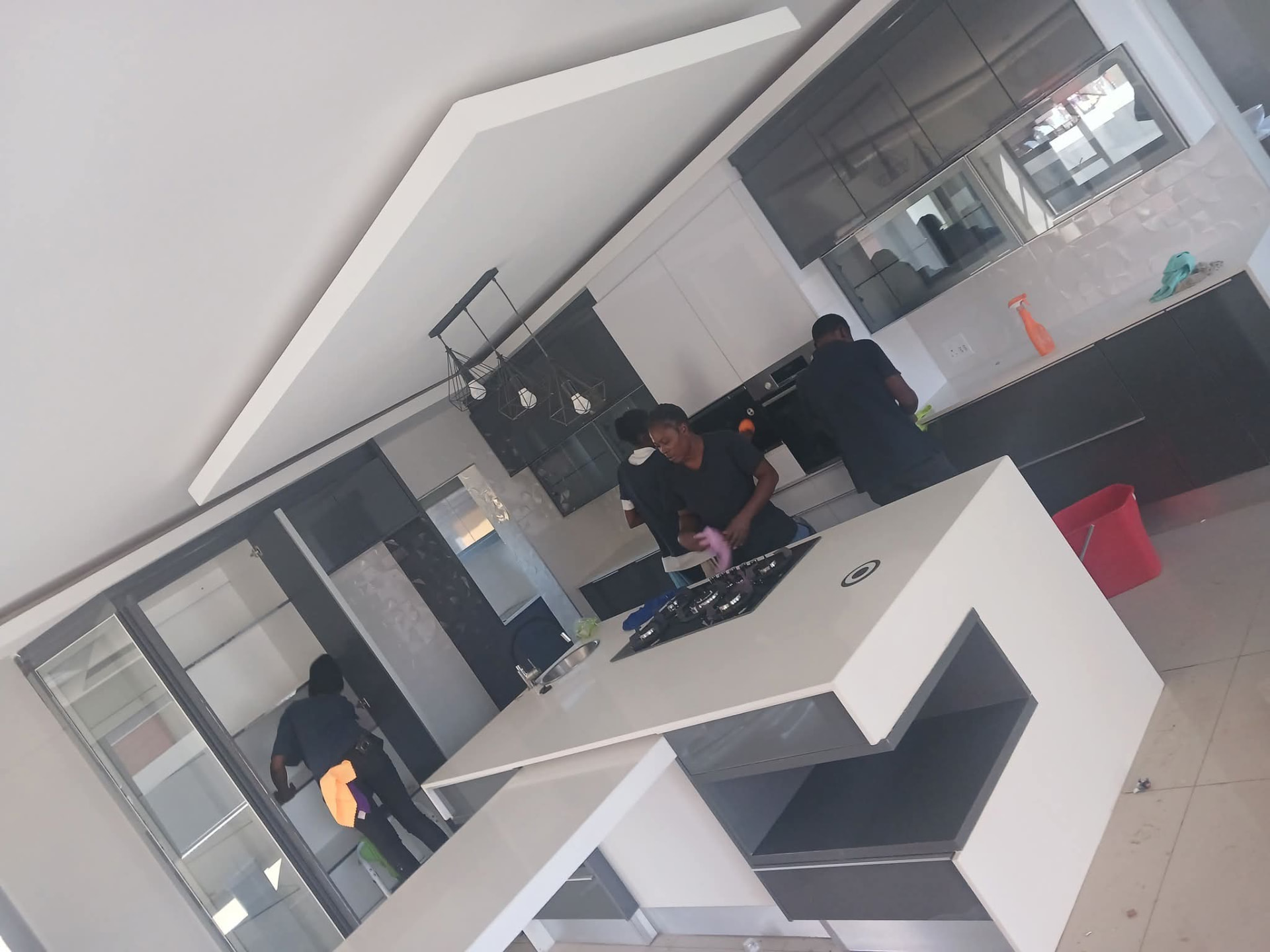 Cleaning team wiping down a modern white kitchen island