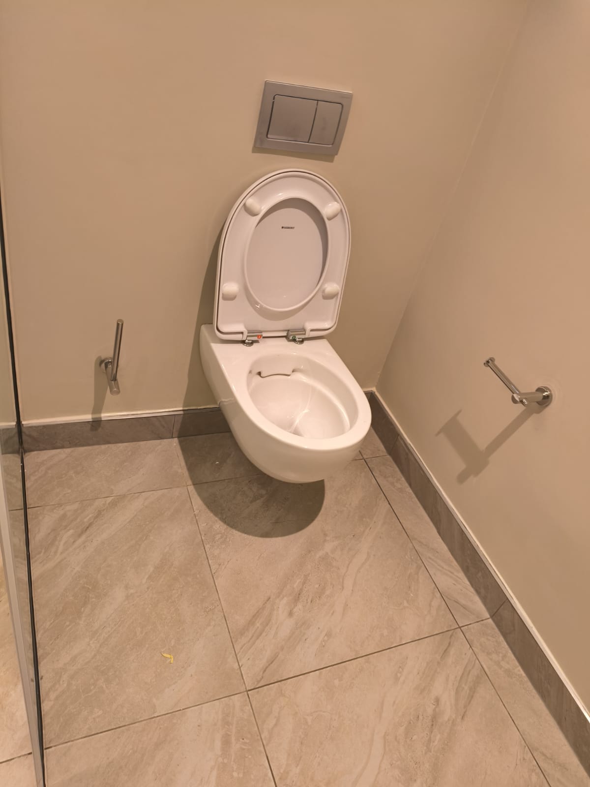 Clean wall-hung toilet and tiled floor