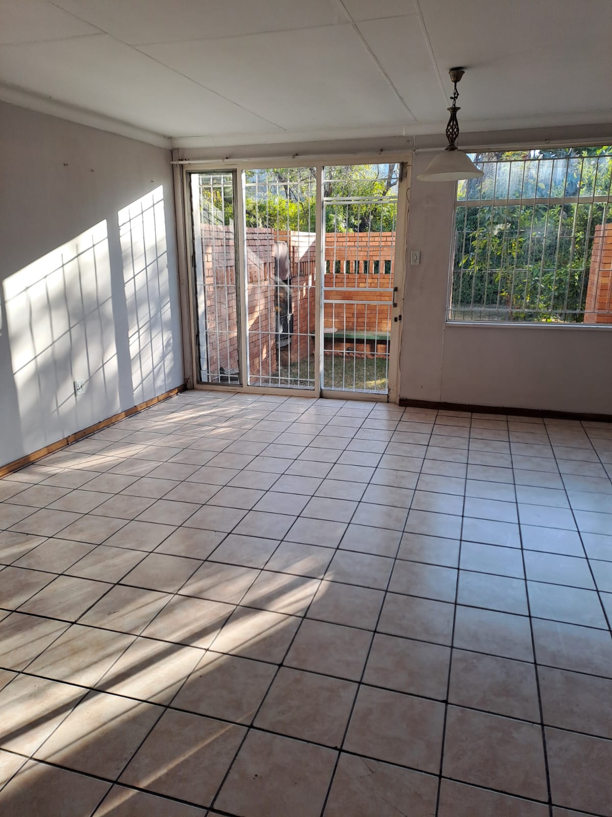 Sunlit empty room with clean tiled floor