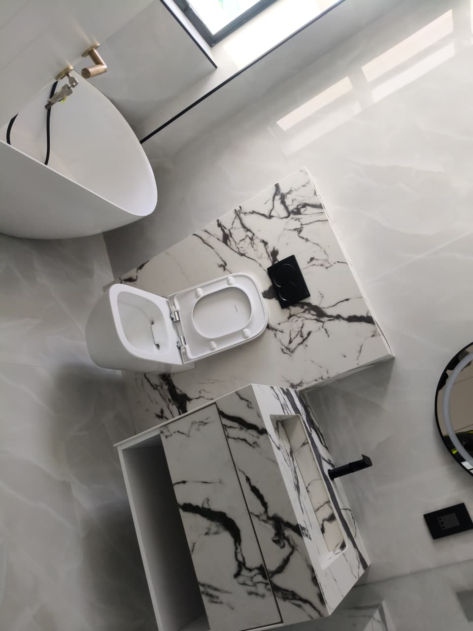 Clean marble bathroom with bath and vanity